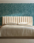Grain Shift Teal minimalist dash wallpaper behind a channel-tufted bed in a calm primary bedroom