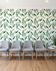 Hanging Garden Emerald botanical wallpaper behind a row of upholstered chairs in a bright clinic waiting room
