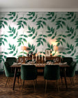 Harvest Crown Emerald leafy branch wallpaper in a dark moody dining room with a candlelit table