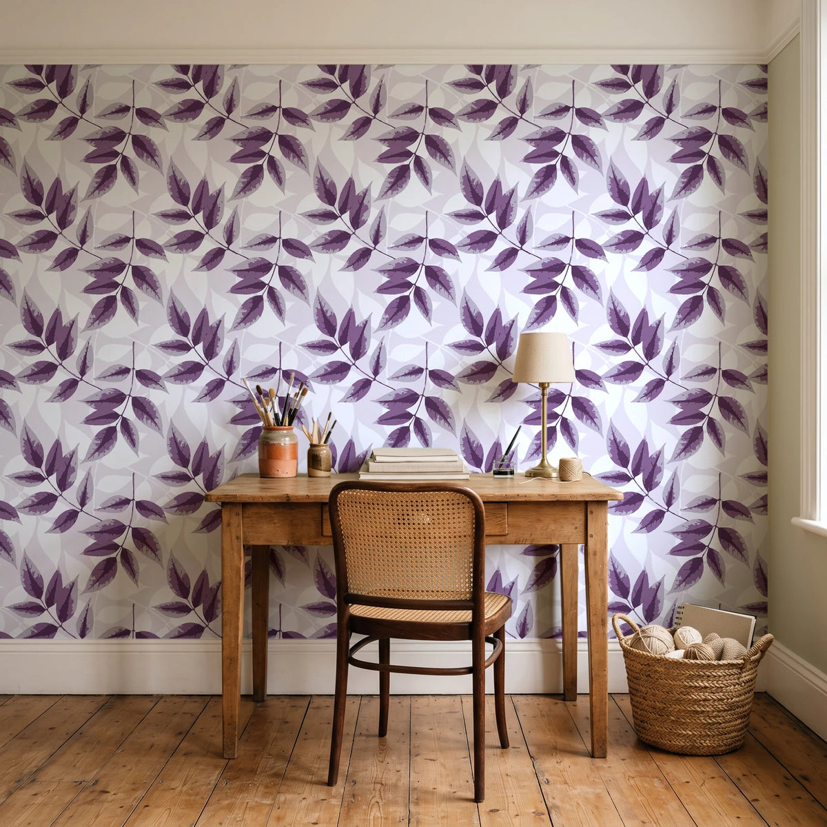 Harvest Crown Plum leafy branch wallpaper behind a vintage writing desk in a cozy craft-room home office