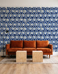 Hidden Court Midnight floral ogee wallpaper behind a rust velvet sofa in a bright coworking lounge