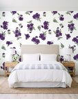 Hidden Garden Aubergine floral wallpaper behind a queen bed in a bright coastal bedroom