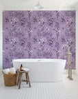 Hush & Palm Plum palm trees wallpaper behind a freestanding tub in a bright coastal bathroom