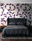 Ink & Oak Aubergine oak leaf and berry wallpaper behind a tufted headboard in a dark, moody bedroom