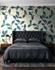 Ink & Oak Teal oak leaf and berry wallpaper behind a tufted headboard in a dark, moody bedroom