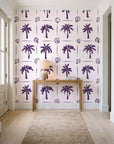 Ink & Shell Aubergine coastal palm and shell wallpaper behind a console table in a light entry hallway