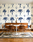 Ink & Shell Navy coastal palm and shell wallpaper in a mid-century dining room with a teak sideboard and tulip table