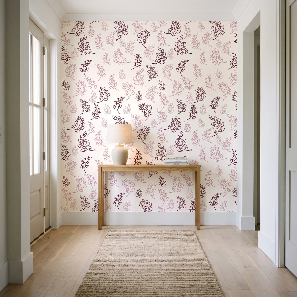 Ink & Sprig Burgundy botanical sprig wallpaper behind a console table in a light entry hallway