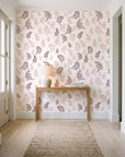 Ink & Sprig Burgundy botanical sprig wallpaper behind a console table in a light entry hallway