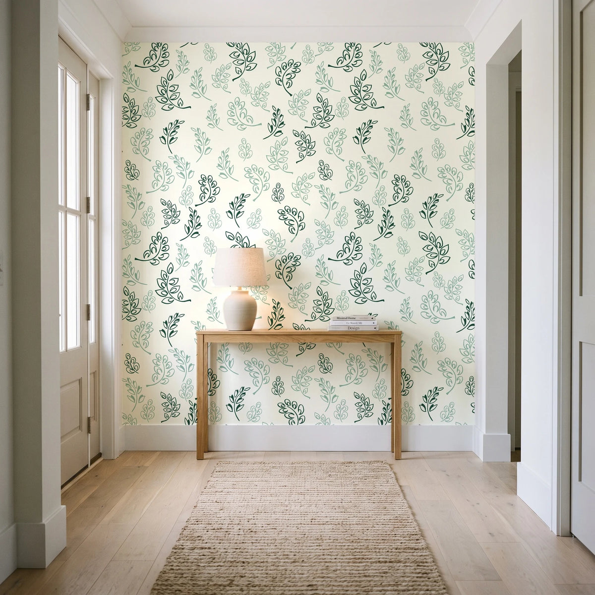 Ink & Sprig Emerald botanical sprig wallpaper behind a console table in a light entry hallway