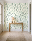 Ink & Sprig Emerald botanical sprig wallpaper behind a console table in a light entry hallway