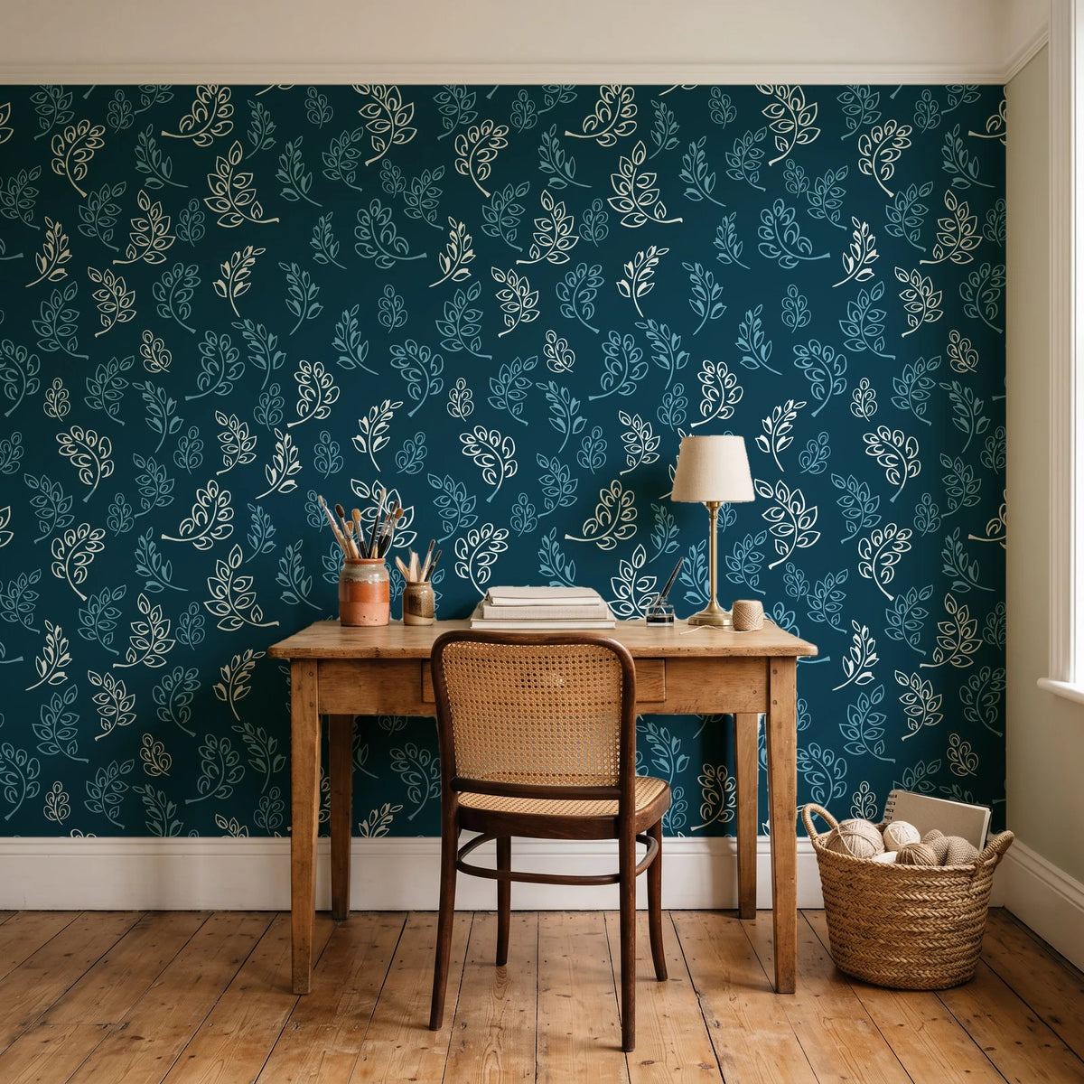 Ink & Sprig Peacock botanical sprig wallpaper behind a vintage writing desk in a cozy craft-room home office