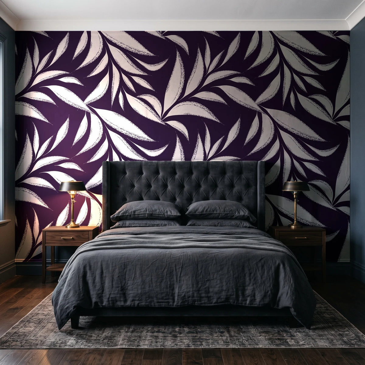 Ink Thicket Aubergine bold leaf wallpaper behind a tufted headboard in a dark, moody bedroom