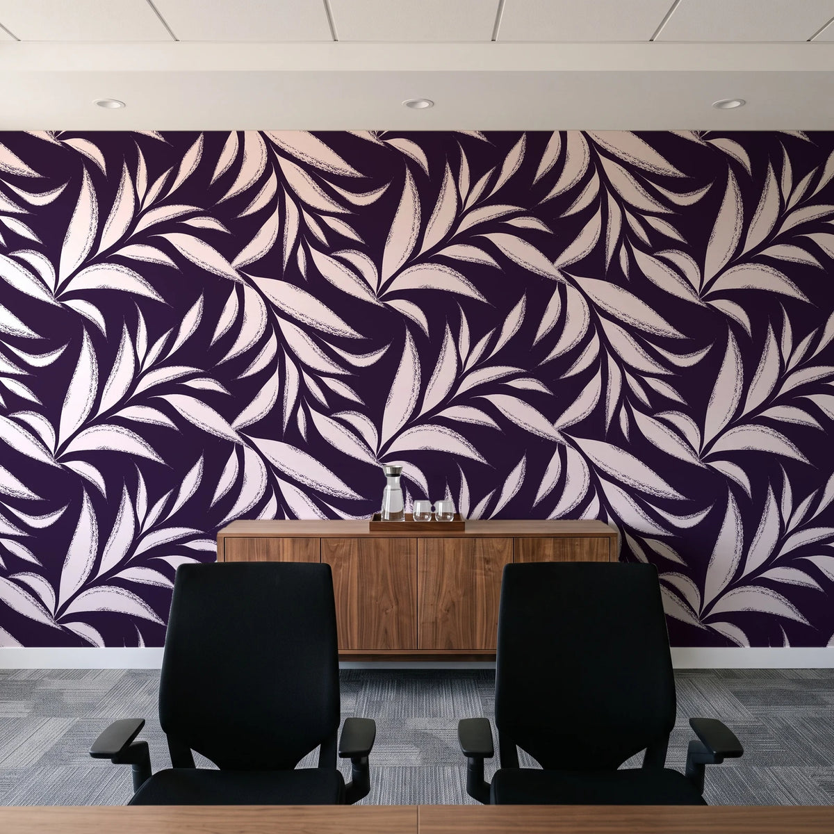 Ink Thicket Aubergine bold leaf wallpaper above a walnut credenza in a modern conference room