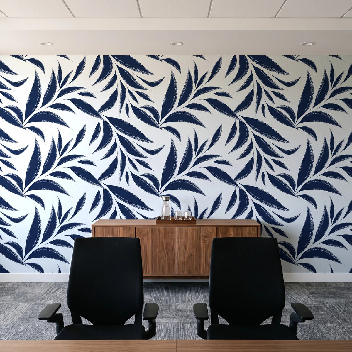 Ink Thicket Midnight bold leaf wallpaper above a walnut credenza in a modern conference room