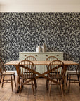 Khaki Leaf Charcoal botanical leaf wallpaper in a farmhouse dining room with a sage sideboard and rustic trestle table