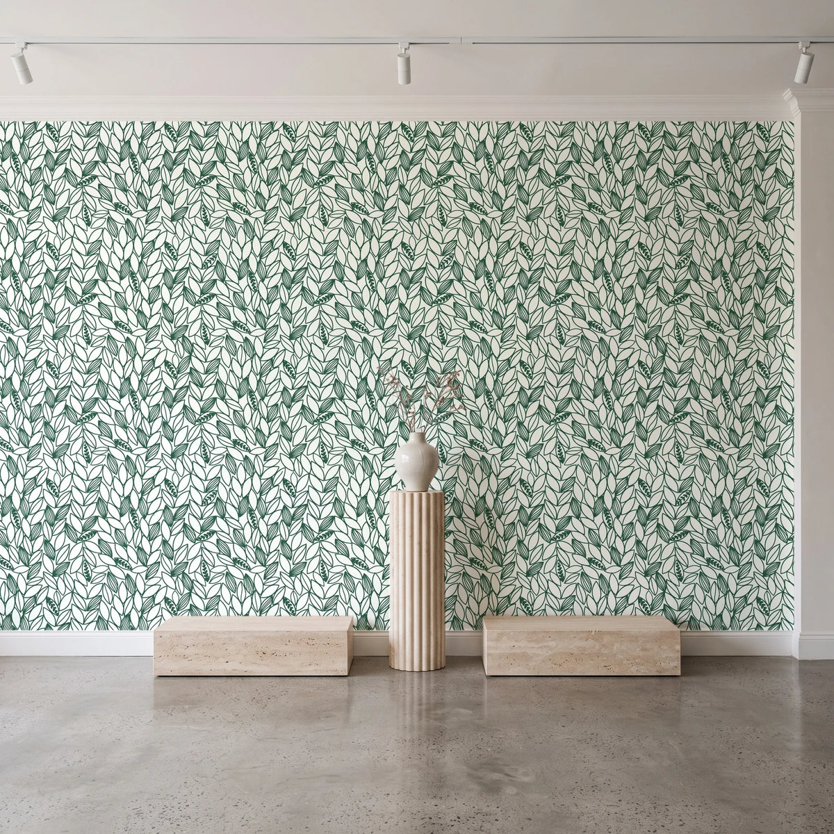 Khaki Leaf Evergreen botanical leaf wallpaper behind a travertine pedestal and vase in a minimal boutique