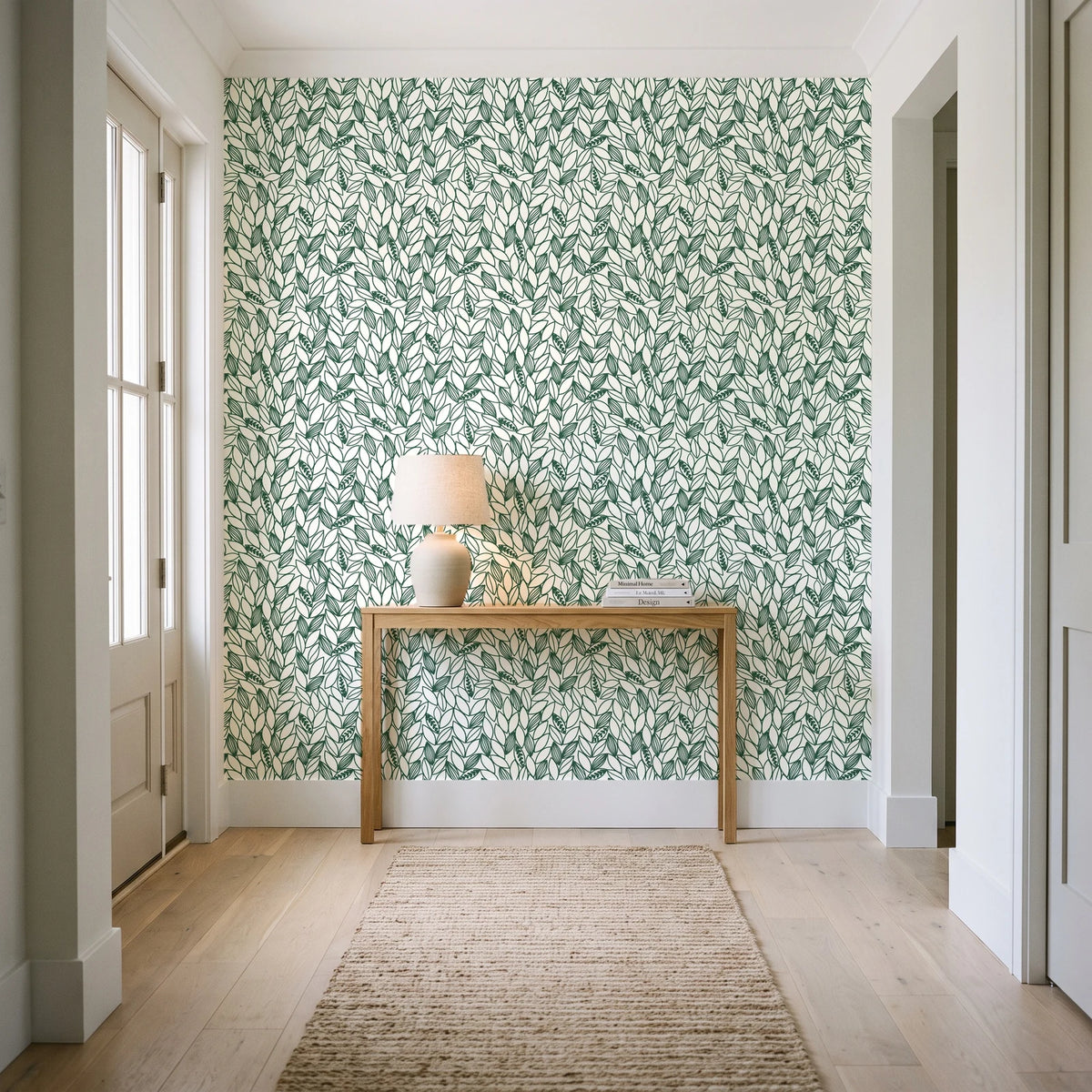 Khaki Leaf Evergreen botanical leaf wallpaper behind a console table in a light entry hallway
