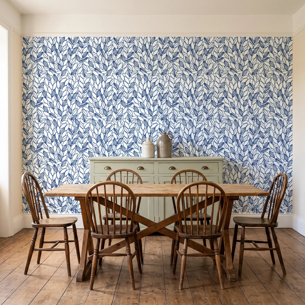 Khaki Leaf Indigo botanical leaf wallpaper in a farmhouse dining room with a sage sideboard and rustic trestle table