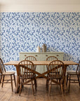 Khaki Leaf Indigo botanical leaf wallpaper in a farmhouse dining room with a sage sideboard and rustic trestle table