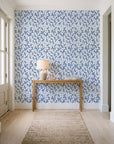 Khaki Leaf Indigo botanical leaf wallpaper behind a console table in a light entry hallway