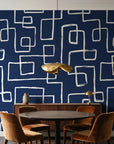 Linear Circuit Navy minimalist line wallpaper behind a walnut credenza and round table in an elegant dining room