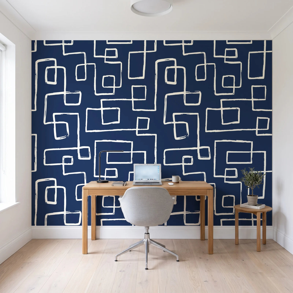Linear Circuit Navy minimalist line wallpaper behind a modern oak desk in a bright home office