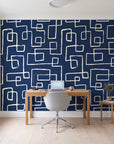 Linear Circuit Navy minimalist line wallpaper behind a modern oak desk in a bright home office