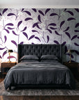 Mistletoe Trail Aubergine mistletoe wallpaper behind a tufted headboard in a dark, moody bedroom