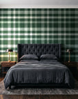 Moors & Mist Forest plaid wallpaper behind a tufted headboard in a dark, moody bedroom