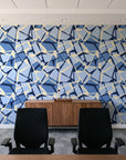 Muted Block Indigo geometric wallpaper above a walnut credenza in a modern conference room