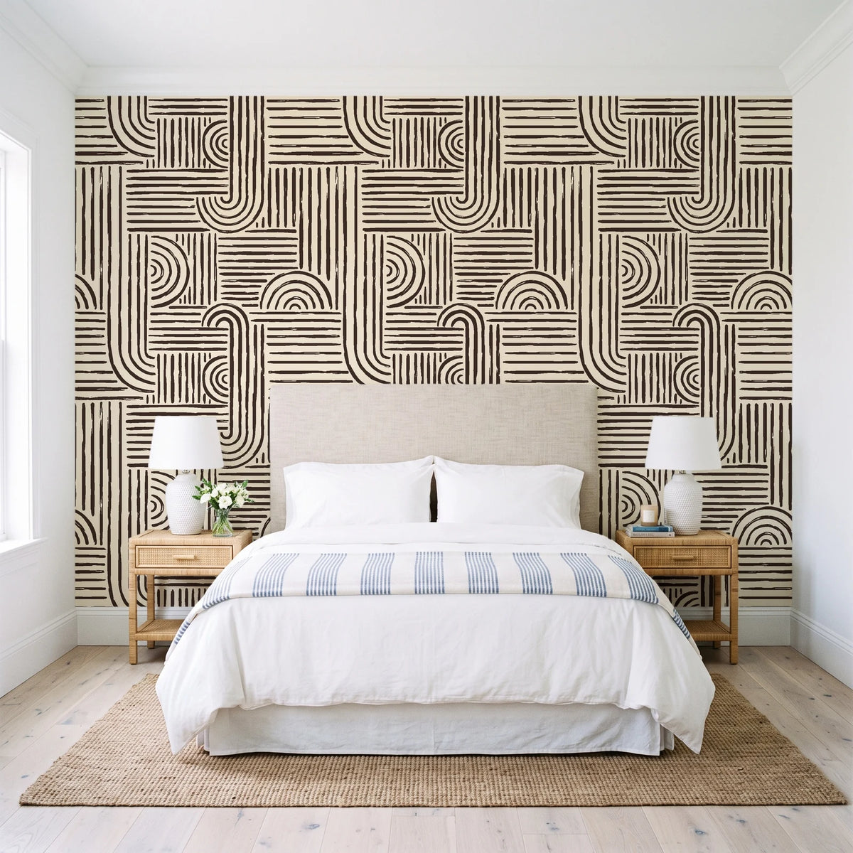 Nomad Stripe Espresso geometric wallpaper behind a queen bed in a bright coastal bedroom