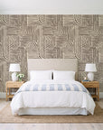 Nomad Stripe Espresso geometric wallpaper behind a queen bed in a bright coastal bedroom