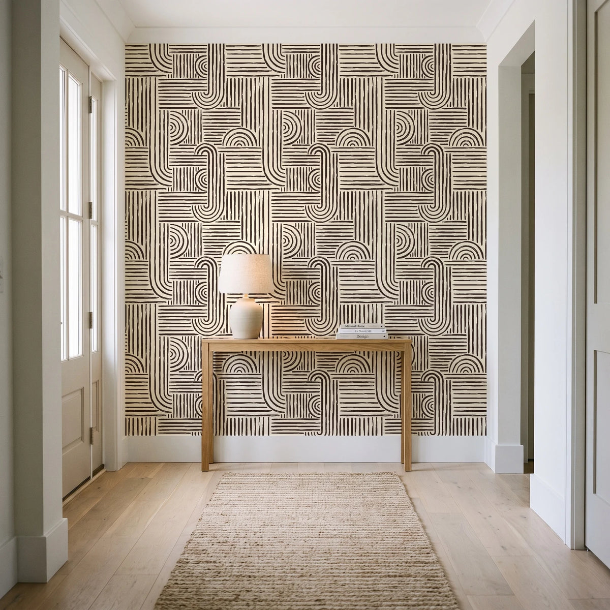Nomad Stripe Espresso geometric wallpaper behind a console table in a light entry hallway