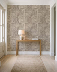 Nomad Stripe Espresso geometric wallpaper behind a console table in a light entry hallway