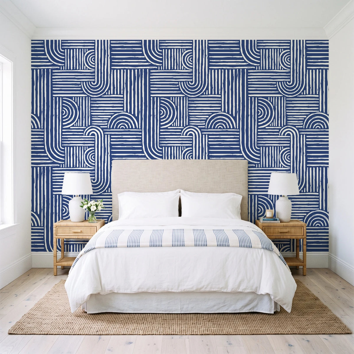 Nomad Stripe Indigo geometric wallpaper behind a queen bed in a bright coastal bedroom