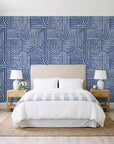 Nomad Stripe Indigo geometric wallpaper behind a queen bed in a bright coastal bedroom