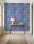 Nomad Stripe Indigo geometric wallpaper behind a console table in a light entry hallway
