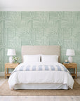 Nomad Stripe Sage geometric wallpaper behind a queen bed in a bright coastal bedroom