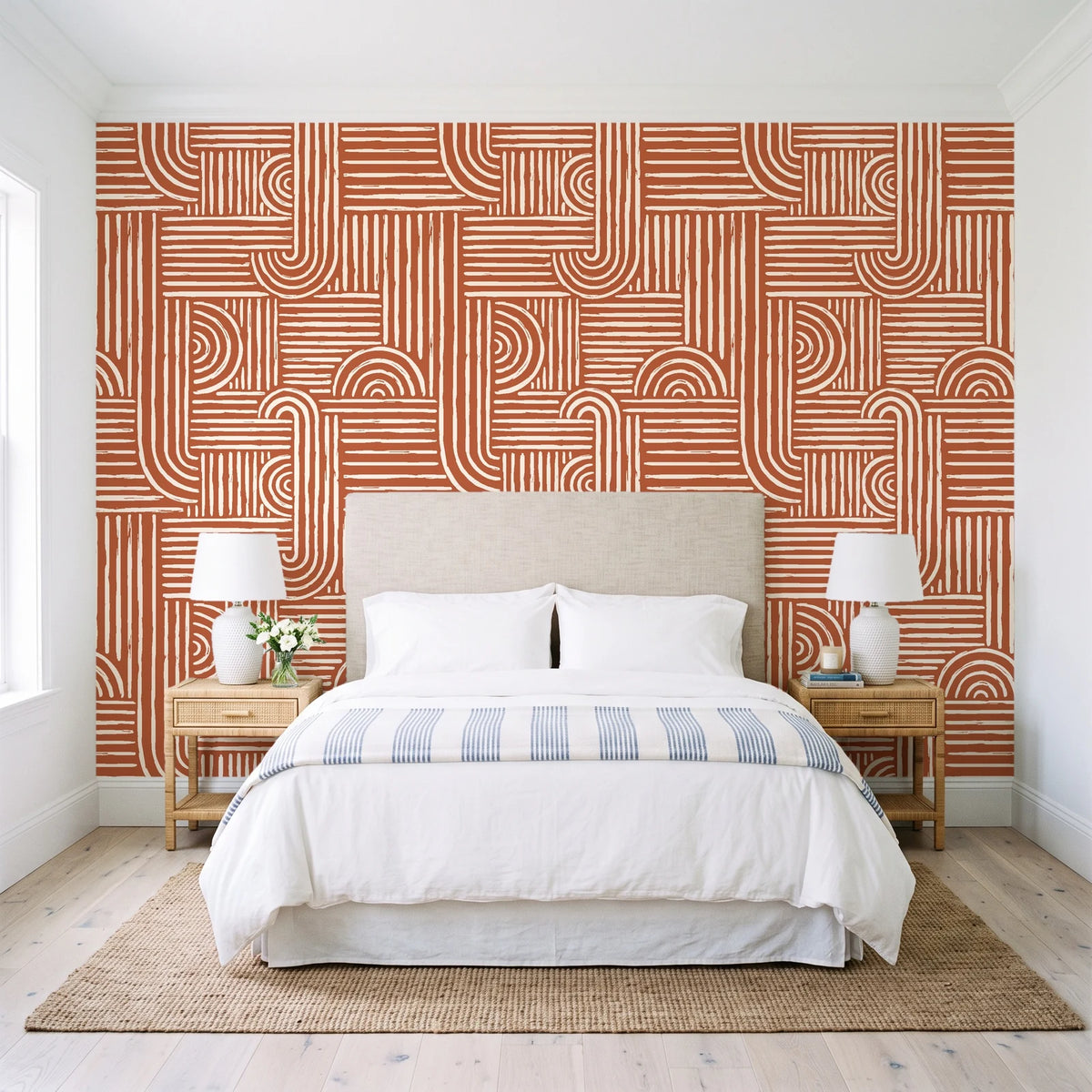 Nomad Stripe Terracotta geometric wallpaper behind a queen bed in a bright coastal bedroom