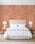 Nomad Stripe Terracotta geometric wallpaper behind a queen bed in a bright coastal bedroom