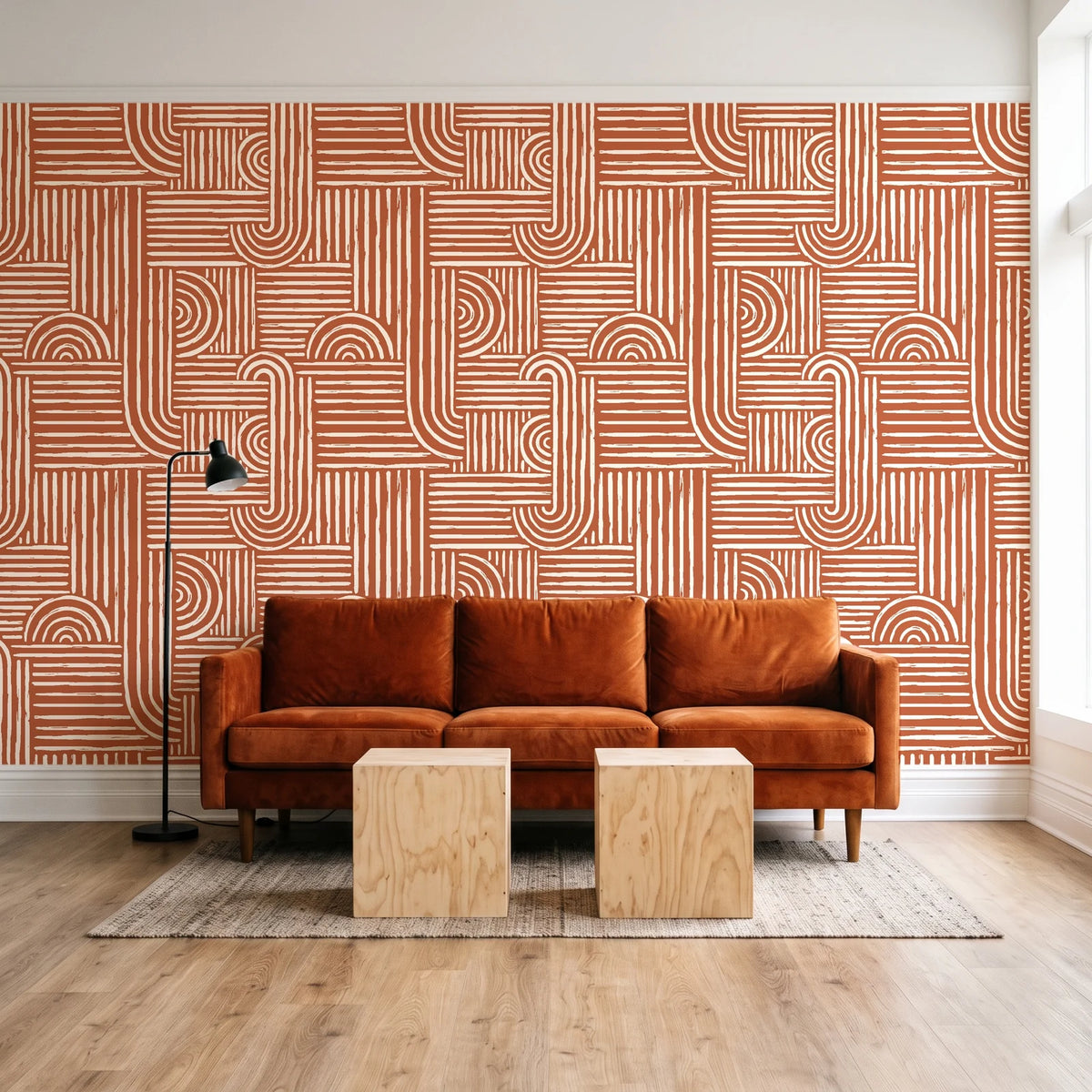 Nomad Stripe Terracotta geometric wallpaper behind a rust velvet sofa in a bright coworking lounge