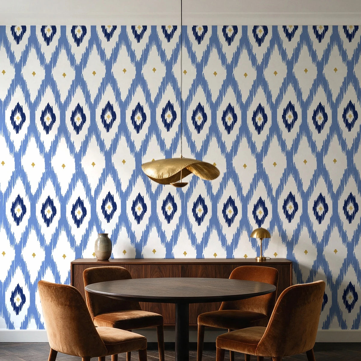 Ogee Loom Indigo ikat ogee wallpaper behind a walnut credenza and round table in an elegant dining room