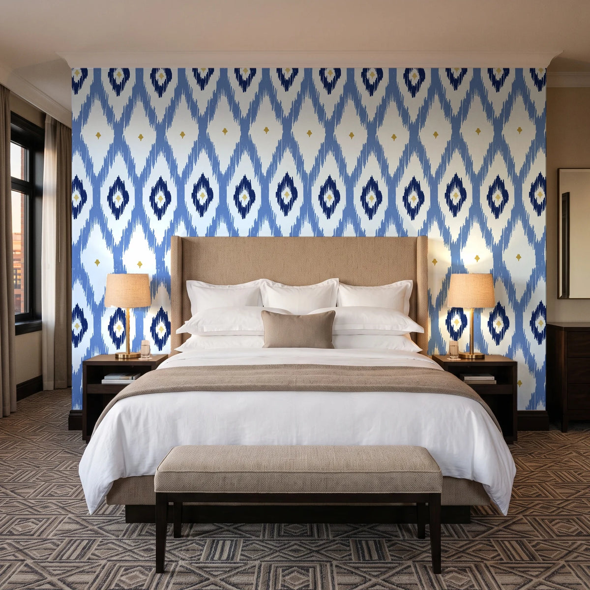 Ogee Loom Indigo ikat ogee wallpaper behind the headboard of a king bed in a contemporary hotel guest room