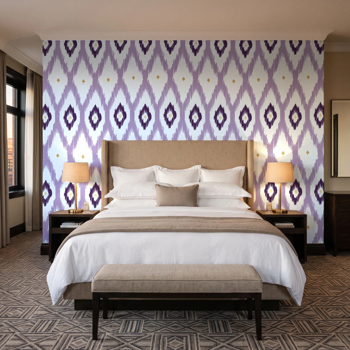 Ogee Loom Plum ikat ogee wallpaper behind the headboard of a king bed in a contemporary hotel guest room