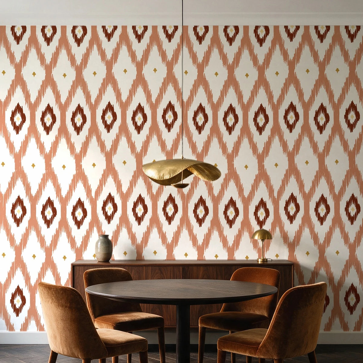 Ogee Loom Terracotta ikat ogee wallpaper behind a walnut credenza and round table in an elegant dining room