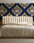 Old World Flora Navy floral damask wallpaper behind a channel-tufted bed in a calm primary bedroom