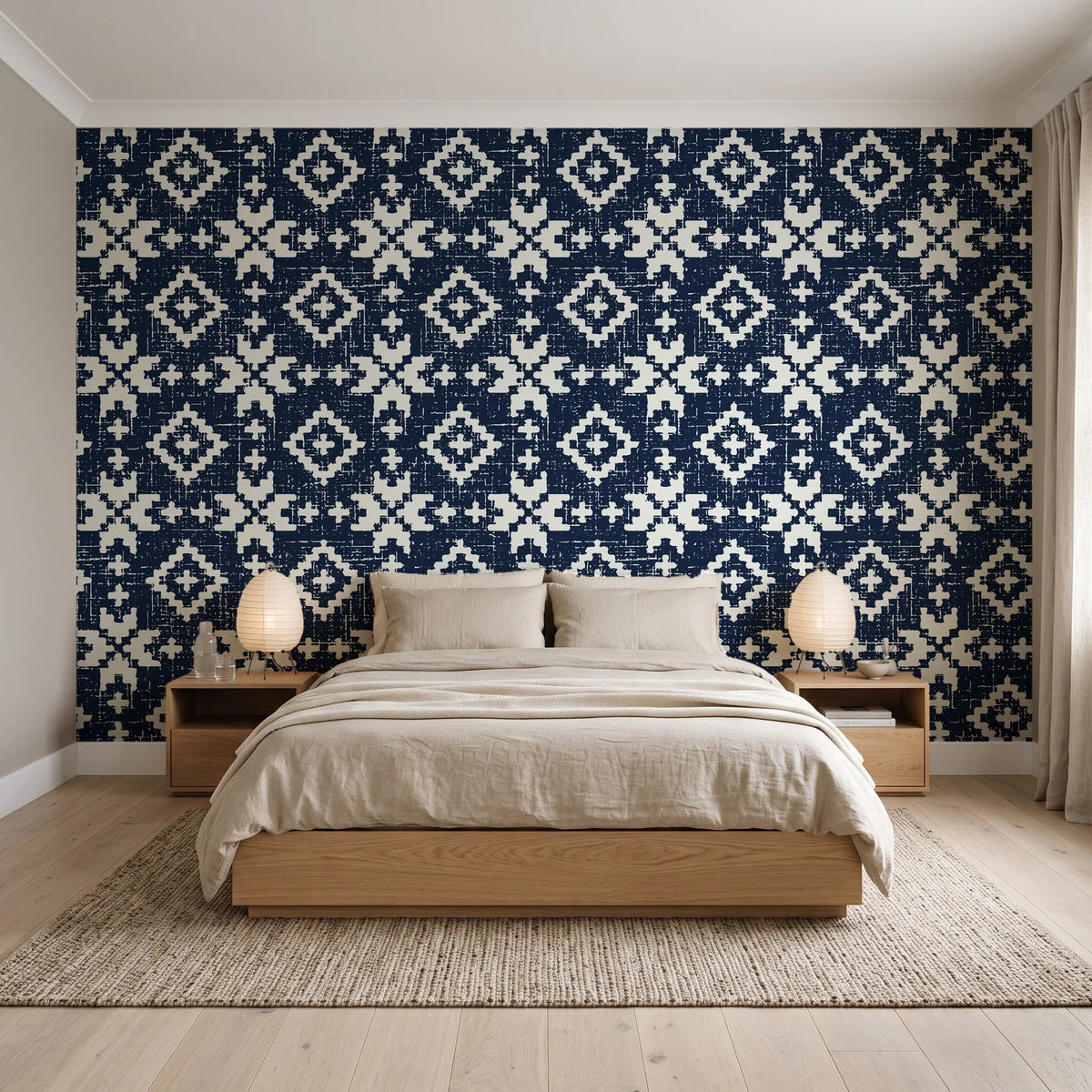 Pale Kilim Midnight kilim wallpaper behind a low platform bed in a serene Japandi bedroom