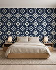 Pale Kilim Midnight kilim wallpaper behind a low platform bed in a serene Japandi bedroom