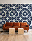 Pale Kilim Midnight kilim wallpaper behind a rust velvet sofa in a bright coworking lounge
